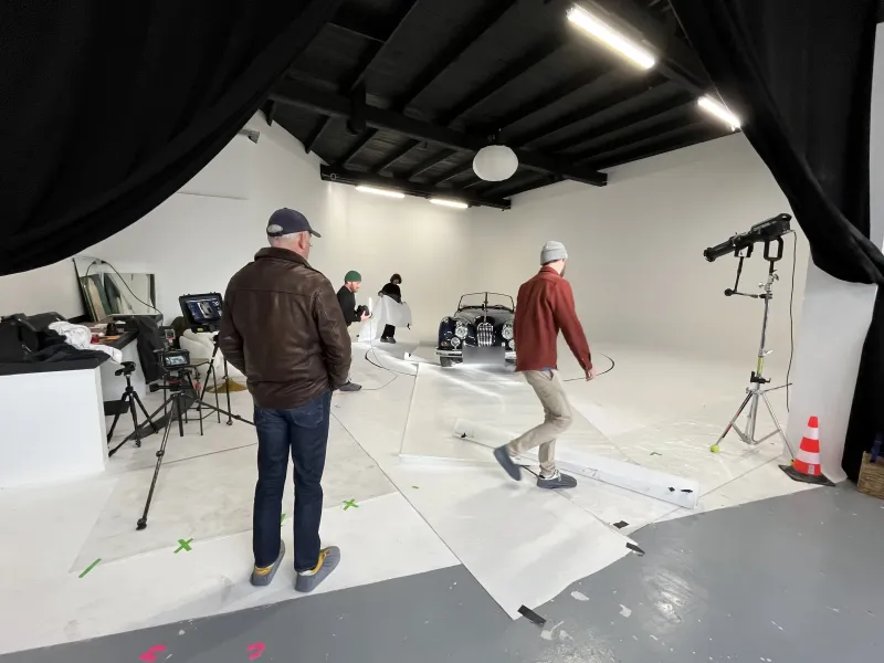 Vue d'ensemble du cyclorama pendant un shooting : équipe, Jaguar XK et rideau noir